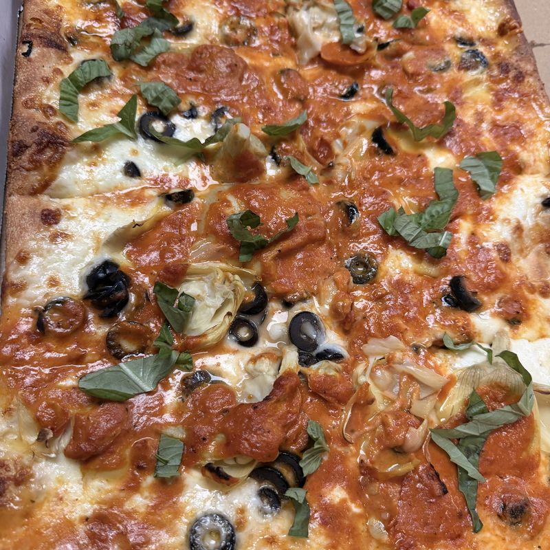 Square vodka pie with artichokes, olives and basil